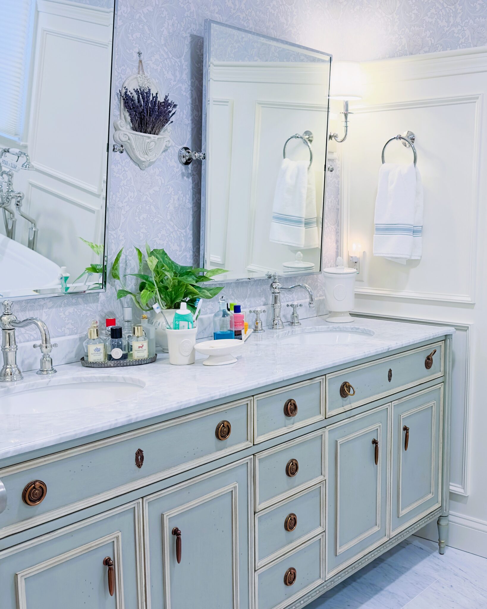 Remodeled bathroom with a light-blue double vanity and marble countertop