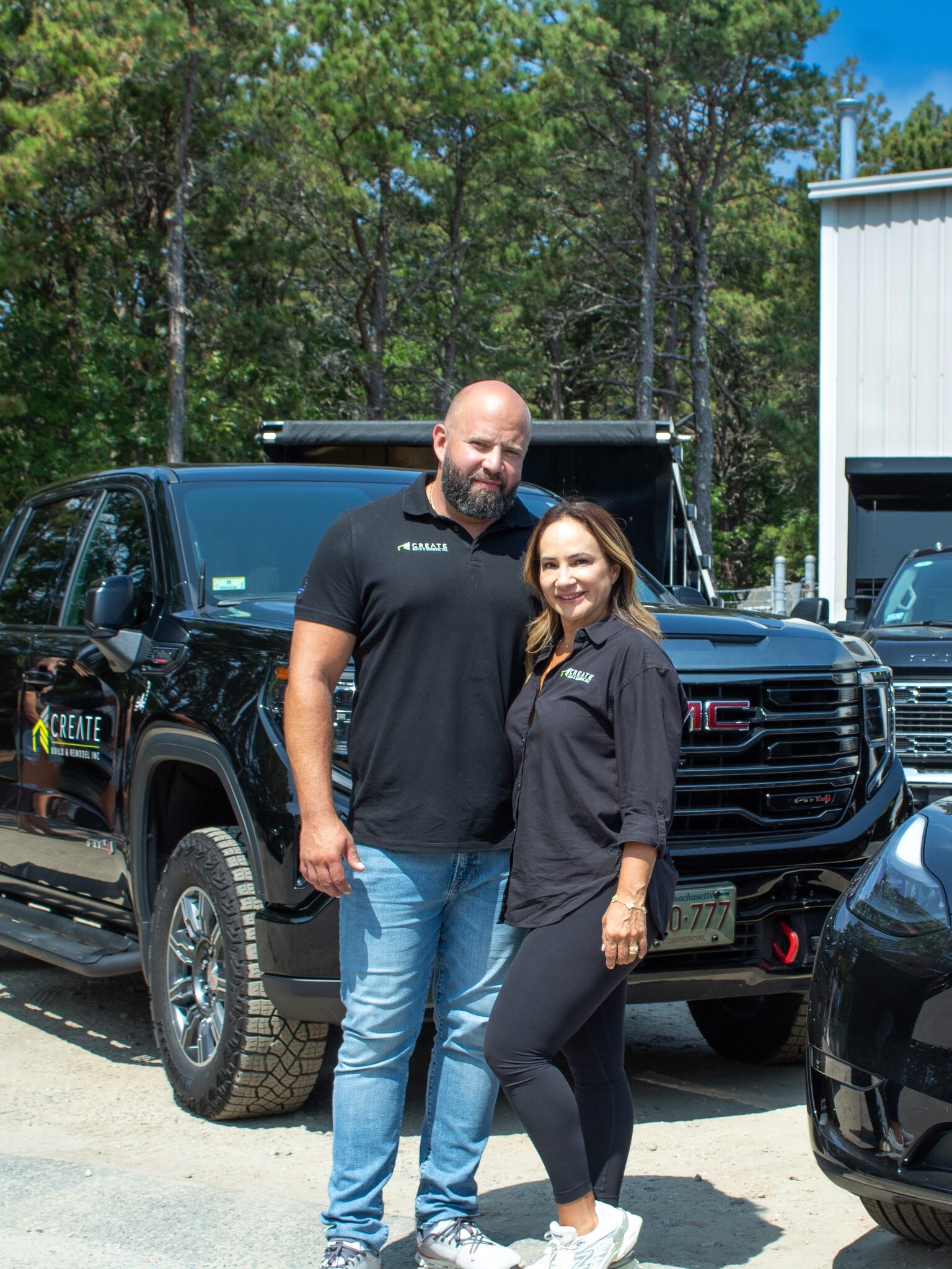 Company owners standing in front of a black Create Build & Remodel pickup truck