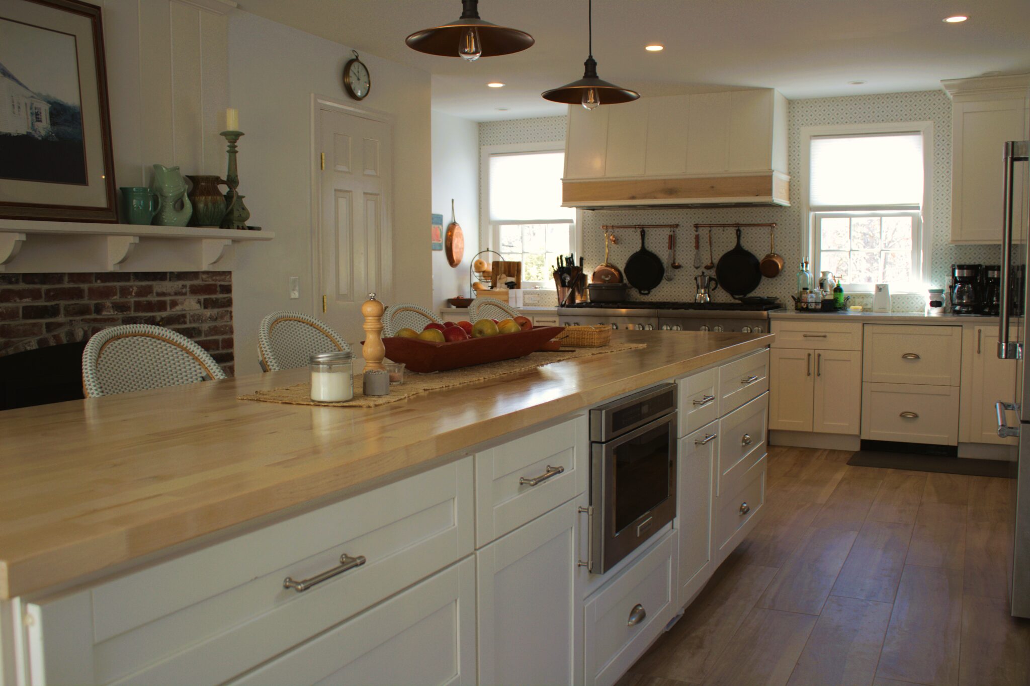 Remodeled farmhouse kitchen with butcher-block counters and brick fireplace surround