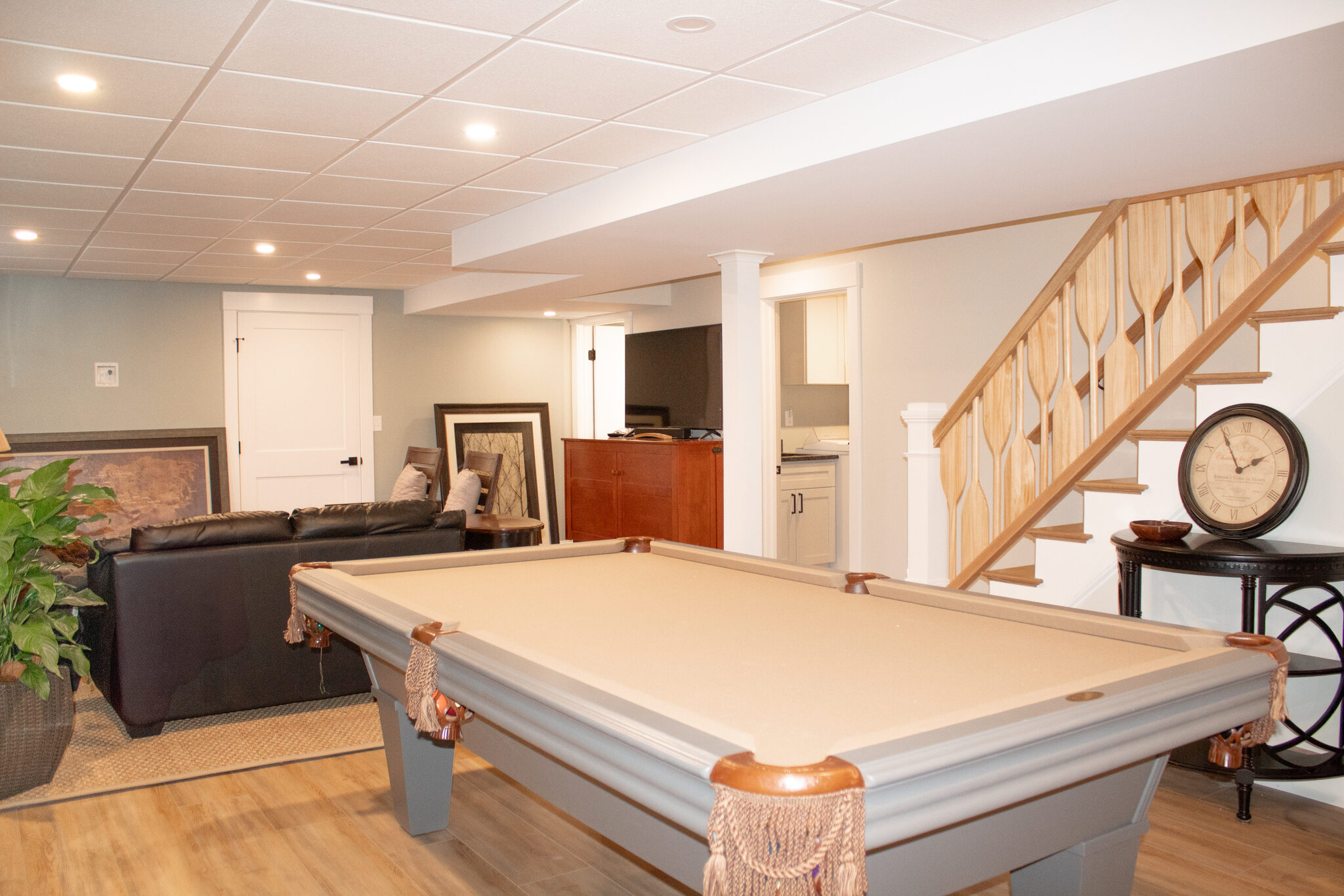 Finished basement with pool table, sitting area and custom wood staircase
