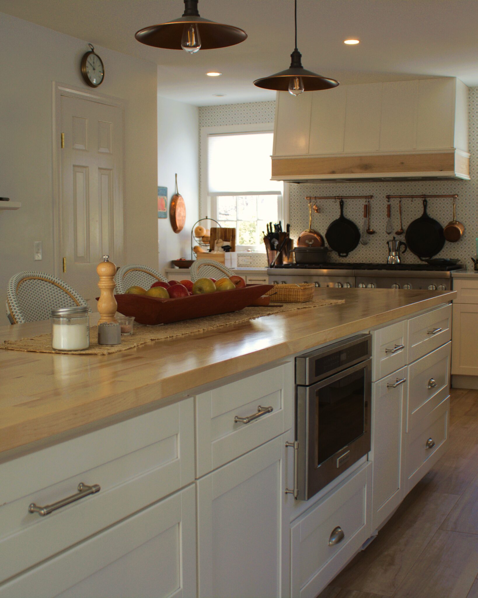 Kitchen remodel with butcher-block island, copper pendant lights and white cabinets